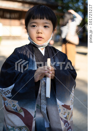 和服姿で七五三のお宮参りに来た5歳児が顎マスクで神社の境内に佇んでいるところ 和服姿で七五三のお宮参りに来た5歳児が顎マスクで神社の境内に佇んでいるところ 101725217