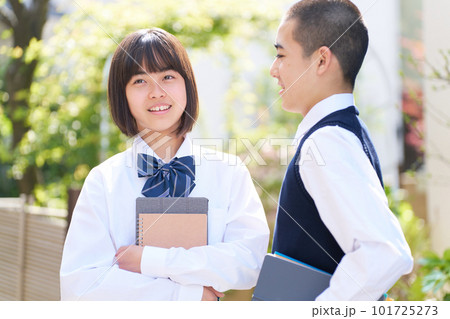 明るい草木の前で会話する中学生の男女 学校 制服 スクールライフ 明るい草木の前で会話する中学生の男女 学校 制服 スクールライフ 101725273
