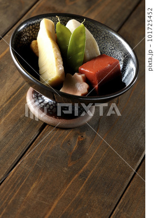 筍や里芋、生麩、サヤエンドウ等が入っている煮物 101725452