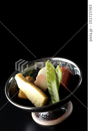 筍や里芋、生麩、サヤエンドウ等が入っている煮物を黒背景で撮影 101725565