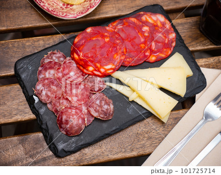 Sliced meat sausages and cheese on serving board Sliced meat sausages and cheese on serving board 101725714