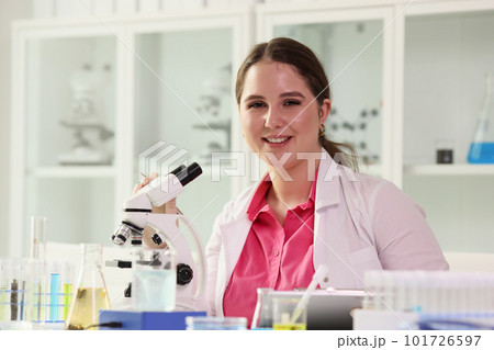 Young female scientist works with microscope in laboratory 101726597