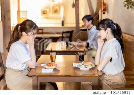 カフェでランチをしながら悩み相談を友達にする若いアジア人女性 101726912