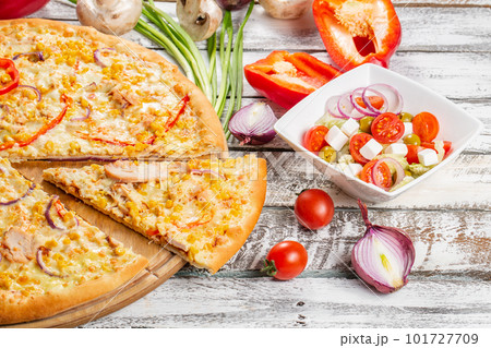 Pizza with chicken, paprika and corn. Italian kitchen and cooking concept. Chief with a pizza cutter cutting pizza to pieces at Neapolitan pizzeria. 101727709