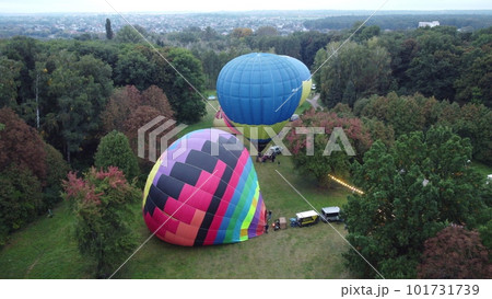Balloon Festival. Inflating and lifting big balloon aerostat. Several balloons inflate and raise in meadow in forest. Entertainment rest, recreation, travelling 101731739