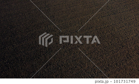 Landscape of plowed up land on an agricultural field on a sunny autumn day. Flying over the plowed earth with black soil. Black soil. Ground earth dirt priming aerial drone view. Agrarian background Landscape of plowed up land on an agricultural field on a sunny autumn day. Flying over the plowed earth with black soil. Black soil. Ground earth dirt priming aerial drone view. Agrarian background 101731749