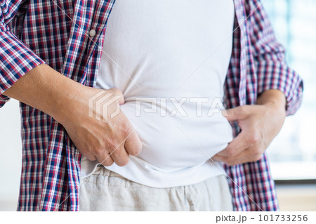 皮下脂肪をつまむ男性の腹と手 101733256