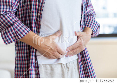 お腹をおさえる男性の手と腹 お腹をおさえる男性の手と腹 101733257