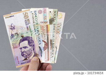 Colombian money - Pesos in the hand on a gray background Colombian money - Pesos in the hand on a gray background 101734654