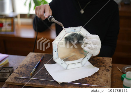 ステンドグラスミラーの製作をする女性 101736151