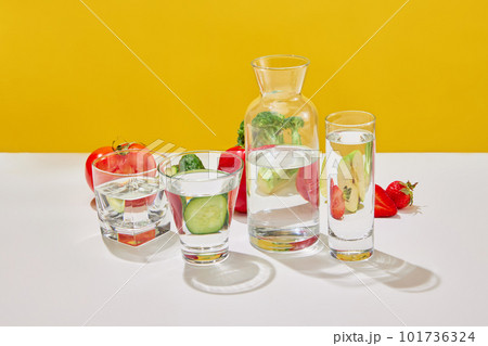 Still life with juicy vegetables and fruits broccoli, tomato, pepper, cucumber, strawberry, apple over yellow studio background. Vitamins for salad. Vegetarian food 101736324
