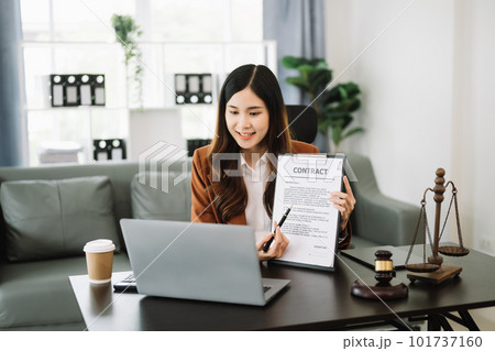 Asian female lawyer chatting online with client on laptop, smartphone discussing details of lawsuit. in modern office Asian female lawyer chatting online with client on laptop, smartphone discussing details of lawsuit. in modern office 101737160