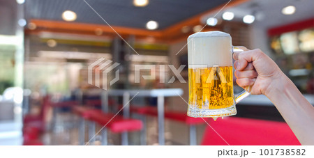Hand shows a glass of beer with foam . Hand shows a glass of beer with foam . 101738582
