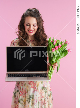 smiling woman showing laptop blank screen on pink smiling woman showing laptop blank screen on pink 101739770