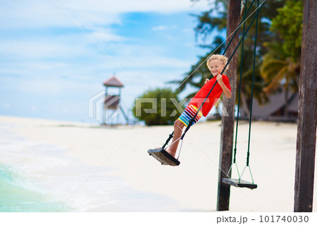 Child on beach swing. Summer vacation. 101740030