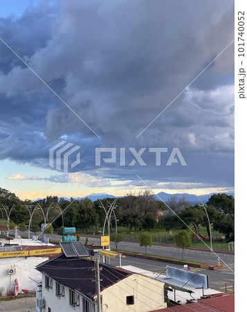 View from the roof of the house to the roofs of houses to the sea, mountains and park, thick low clouds 101740052