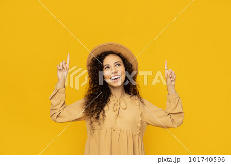 Young woman in dress on yellow background 101740596