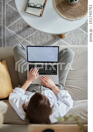 Mockup white screen laptop woman using computer sitting on sofa at home, top view 101740761