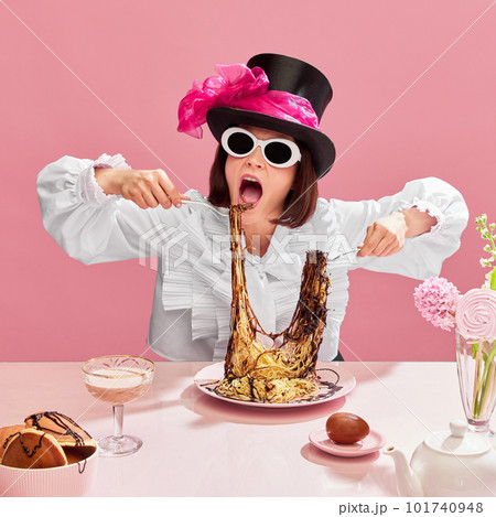 Passionate eater. Emotinal woman in cylinder hat and suglasses eating spaghetti with chocolate sauce against pink background. 101740948