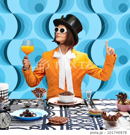 Chocolate lover. Stylish young woman in top hat, sunglasss and orange jaket drinking juice and eating chocolate sweets 101740978