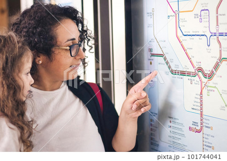 A young mother and daughter looking and pointing at a city metro underground map A young mother and daughter looking and pointing at a city metro underground map 101744041