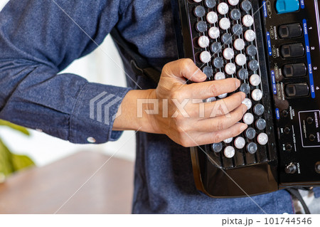 クロマチックボタン式アコーディオンを弾いている男性の手元 101744546