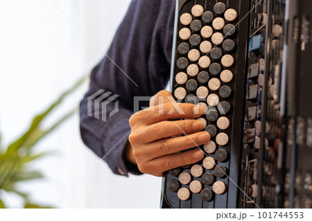 クロマチックボタン式アコーディオンを弾いている男性の手元 クロマチックボタン式アコーディオンを弾いている男性の手元 101744553