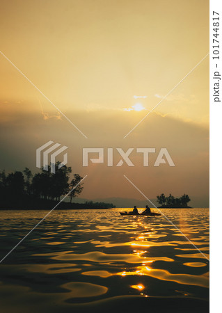 Silhouettes of people in kayak at sunset. 101744817