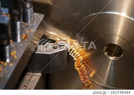 Close-up the lathe machine finish cutting the brass disk parts by lathe tools. 101746484