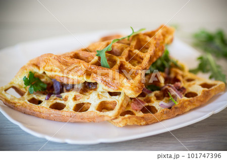 Egg omelette stuffed with onions and herbs, fried in the form of waffles 101747396