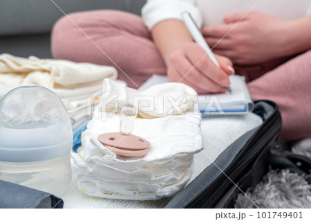 Pregnant woman writing list of things for maternity hospital. Concept of expecting a baby 101749401