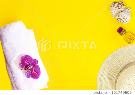 Layout is summer, beach. White terry towel with purple orchid, straw hat, bottle of perfume, seashells on yellow background. Travel and tourism. Copy space Layout is summer, beach. White terry towel with purple orchid, straw hat, bottle of perfume, seashells on yellow background. Travel and tourism. Copy space 101749609
