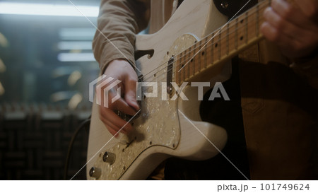 Musician plays on electric guitar in recording studio 101749624