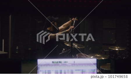 Sound engineer tunes musical instruments in recording room Sound engineer tunes musical instruments in recording room 101749658