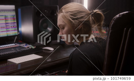 Female musician uses electric piano in recording studio Female musician uses electric piano in recording studio 101749659