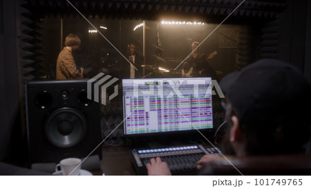 Experienced audio engineer looks at musicians work Experienced audio engineer looks at musicians work 101749765