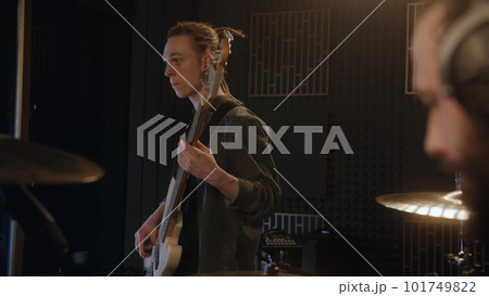 Male guitarist plays the electric guitar in music recording room Male guitarist plays the electric guitar in music recording room 101749822