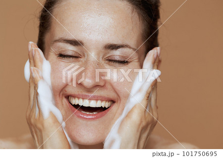 happy young woman with foaming facial cleanser washing face happy young woman with foaming facial cleanser washing face 101750695