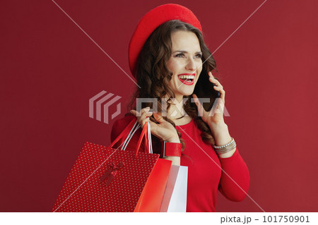 smiling stylish woman in dress and beret talking on phone 101750901