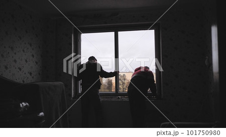 Silhouettes of workers installing new plastic windows. 101750980