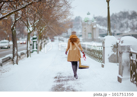 Seen from behind woman in brown hat and scarf 101751350