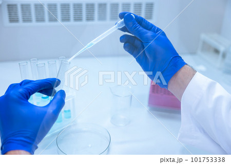 Scientist hands with dropper or pipette, examining samples and liquid. Scientist hands with dropper or pipette, examining samples and liquid. 101753338