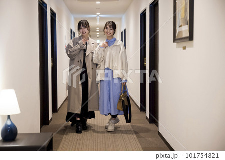 チェックインをしてホテルの廊下を歩く若い女性たち 101754821