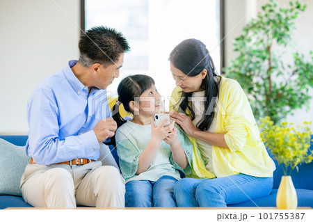 スマホを見る孫と祖父母 101755387