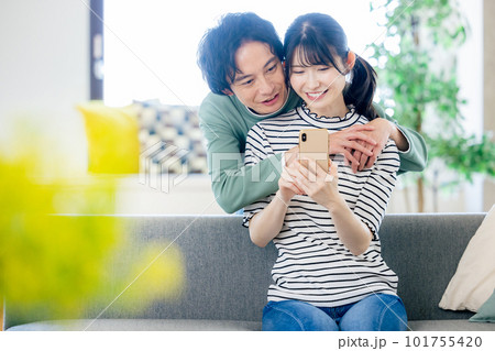 スマホを見る若い夫婦 スマホを見る若い夫婦 101755420