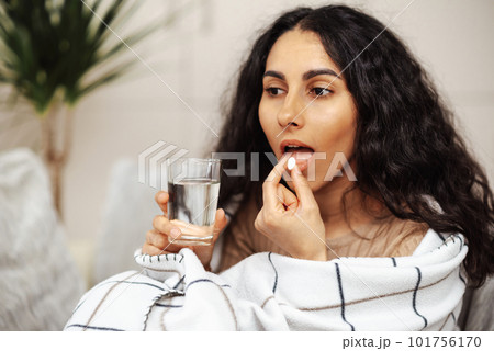 Pretty young woman taking medicine. Pill as a means for treatment or beauty. 101756170