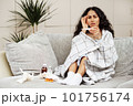 Young woman looks at the thermometer with horror. 101756174