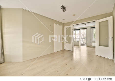an empty living room with wood flooring and white walls in the room is very clean, but there is no light 101756366