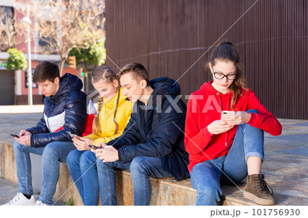 Teenagers chatting on their smartphone on walking Teenagers chatting on their smartphone on walking 101756930