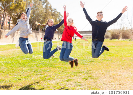 Four joyful teens jump on a lawn Four joyful teens jump on a lawn 101756931